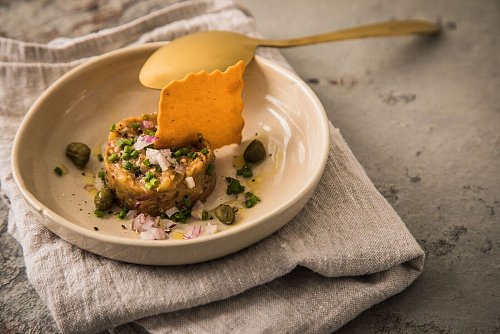 In den Niederlanden gibt es Filet Americain in verschiedenen Versionen, zur Abwechslung oder für Vegetarier als Taler aus Auberginen-Tatar mit Kapern, Schnittlauch, Olivenöl und einem Cracker. - © Christin Klose/dpa-tmn