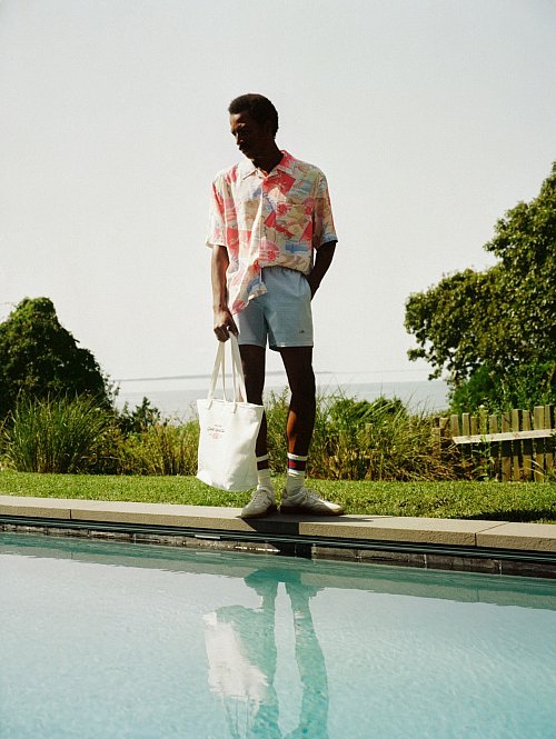 Kurzarmhemden mit Print sehen in Kombination mit Shorts - hier von Gant - besonders modisch aus. Und auch der große Shopper gehört zu den It-Pieces (Shirt ca. 150 Euro, Shorts ca. 150 Euro, Tasche ca. 130 Euro, Socken ca. 14 Euro, Sneaker ca. 130 Euro). - © Gant/dpa-tmn