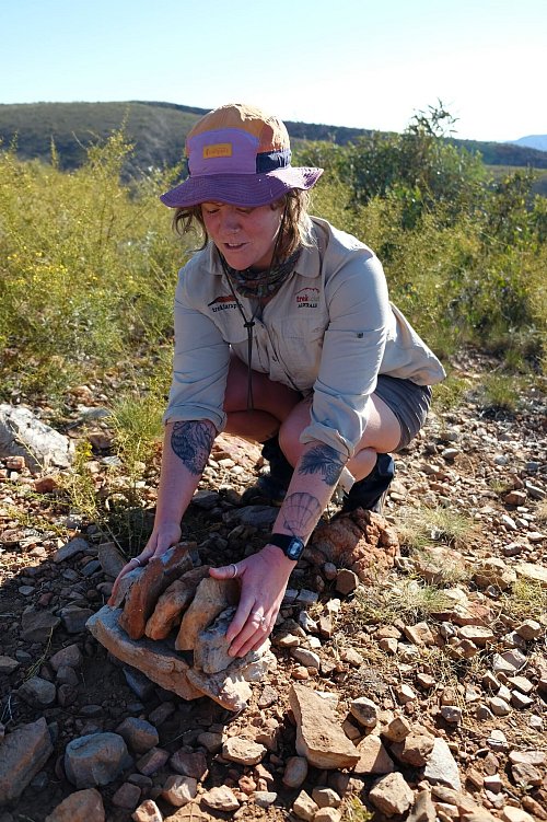 Lektion am Wegesrand: Tash Loh erklärt die Geologie der MacDonell Ranges. - © Florian Sanktjohanser/dpa-tmn