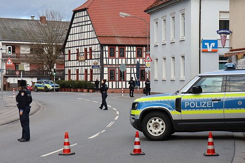 Polizeibeamte sichern die Straße rund um die Bankfiliale. - © René Priebe/PR-Video/dpa