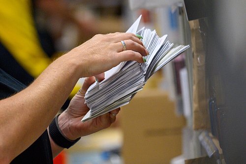 Eine Mitarbeiter der Deutschen Post sortiert in einem Zustellstützpunkt der Post Briefe. - © Klaus-Dietmar Gabbert/dpa