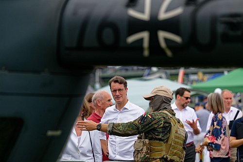 Hendrik Wüst, Ministerpräsident des Landes Nordrhein-Westfalen (CDU), spricht beim Nordrhein-Westfalen-Tag mit einem Soldaten. - © Henning Kaiser/dpa