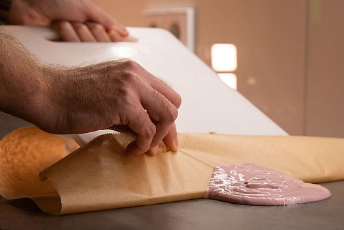 Schritt 2: Mit Hilfe des Schneidebretts den Joghurt auf das Backpapier schieben. - © Christin Klose/dpa-tmn