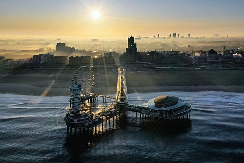 Seebrücke mit Fahrgeschäft: Das Riesenrad vor dem Strand von Scheveningen dreht sich bis in die Nacht. - © Liset Verberne/NBTC/dpa-tmn