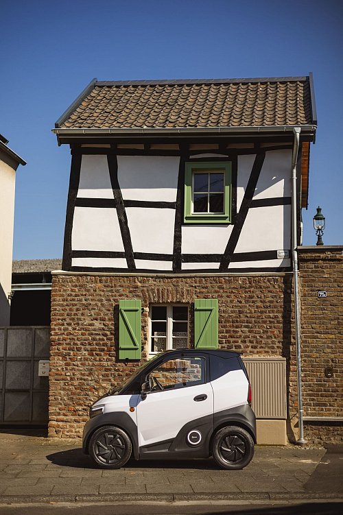 Altes Tiny House hinter neuem Tiny Car: Das rund 2,28 Meter lange Gefährt spielt in der Innenstadt bei der Parkplatzsuche seine Trümpfe voll aus. - © Nissan/dpa-tmn