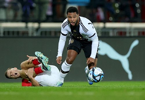 Ende 2023 war Serge Gnabry (r) beim 0:2 gegen Österreich in Wien zuletzt im Nationaltrikot im Einsatz. - © Christian Charisius/dpa