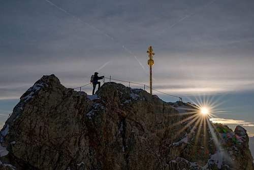 Das Gipfelkreuz ist mit Hunderten Stickern beklebt und muss restauriert werden. - © Peter Kneffel/dpa