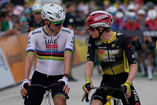 Die Top-Stars und Konkurrenten Tadej Pogacar (L) und Jonas Vingegaard unterhalten sich vor dem Start der 112. Tour de France. - © Mosa\\\'ab Elshamy/AP/dpa