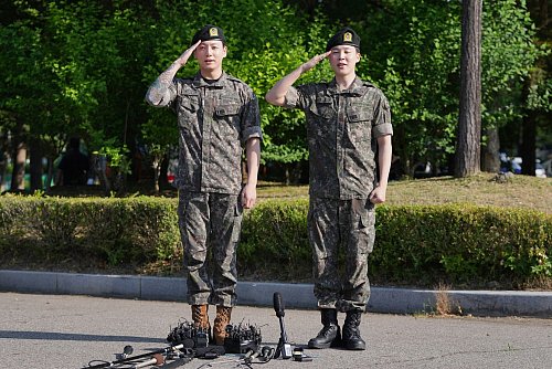 Jung Kook und Jimin (rechts) salutieren im Juni nach ihrer Entlassung aus dem Militärdienst. (Archivbild) - © Lee Jin-man/AP/dpa