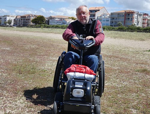 Bernhard Endres an der Atlantikküste: An seinem Rollstuhl ist ein Zuggerät mit Elektromotor gekoppelt. - © Bernhard Endres/dpa-tmn