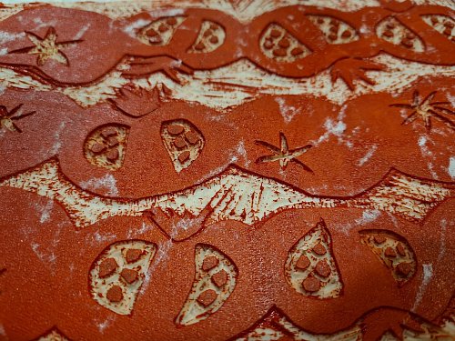 Detailansicht eines Linolschnitts: Zuerst wird das Motiv in die Linoleumplatte geritzt, dann die Farbe mit einer Gummiwalze aufgetragen und anschließend die Tomaten auf Stoff oder Papier gedruckt. - © Isabelle Modler/dpa-tmn