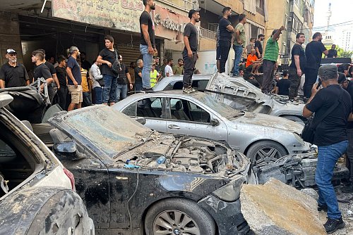 Menschen versammeln sich nach einem israelischen Angriff in Libanons Hauptstadt Beirut. - © Bilal Hussein/AP