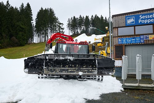 Mit der Pistenraupe wird der künstlich erzeugte Schnee ausgebreitet. - © Bernd Thissen/dpa