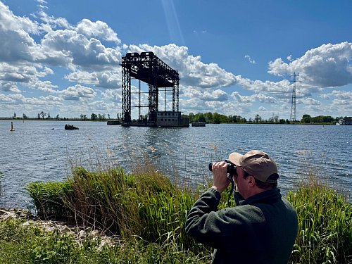 Ulf Wigger hält Ausschau nach Seeadlern - im Hintergrund: die historische Hubbrücke Karnin. - © Wolfgang Stelljes/dpa-tmn