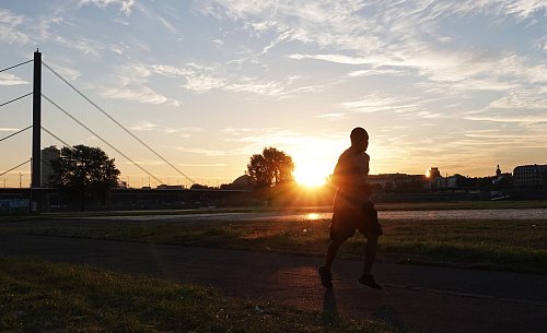 Ein Jogger in Düsseldorf: Auch Sport kann an extremen Hitzetagen gefährlich werden. - © Lukas Fortkord/dpa