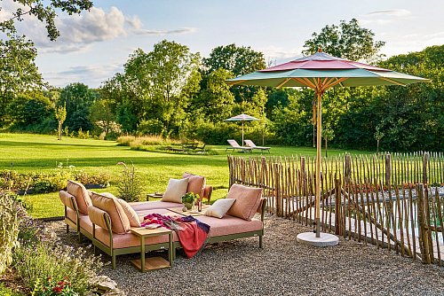 Gemütlichkeit in zarten Grün- und Rosé-Tönen: Die Liegen von Weishäupl Möbelwerkstätten schaffen im Garten einen Rückzugsort zum Relaxen. - © Weishäupl Möbelwerkstätten/dpa-tmn
