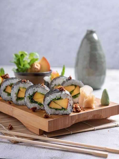 Die Algenblatt- und Reisgrundlage von Maki-Sushi kann jeweils saisonal passend gefüllt werden: hier mit Pfirsich und Basilikum. - © Alex Neumayer/Christian Verlag/dpa-tmn