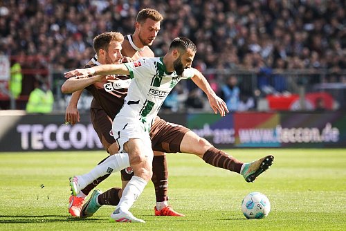 Möchengladbachs Franck Honorat (vorn) behauptet den Ball gegen die Hamburger Lars Ritzka (l) und Hauke Wahl. - © Christian Charisius/dpa