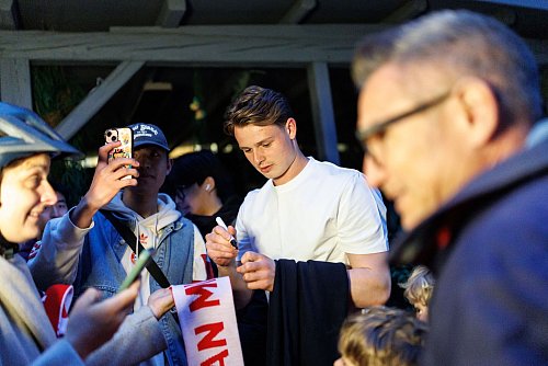 Torhüter Jonas Urbig schreibt Autogramme, bevor er mit seinen Teamkollegen feiert. - © Matthias Balk/dpa