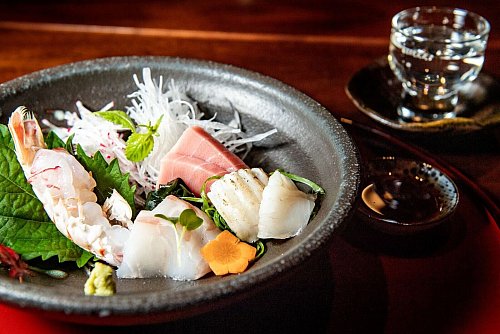 Sashimi ist roher Fisch ohne Beilagen, lediglich mit ein paar Würzzutaten serviert. Sojasoße, Wasabi und Kresse sind typische Aromen zur Verfeinerung - © Zacharie Scheurer/dpa-tmn