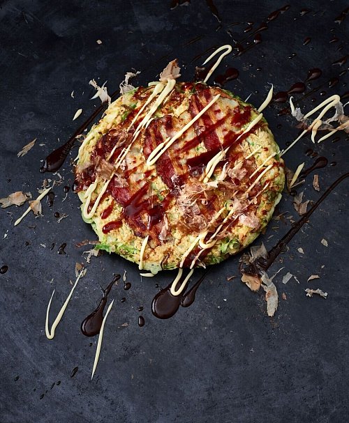 Okonomiyaki ist ein Wohlfühlgericht der japanischen Küche. Der herzhafte Pfannkuchen, der oft auch als «japanische Pizza» bezeichnet wird, besteht aus einem einfachen Teig auf der Basis von Mehl, Ei und Dashi-Brühe und wird mit fein geschnittenem Kohl verfeinert. - © Julia Hörsch/Gräfe und Unzer Verlag/dpa-tmn