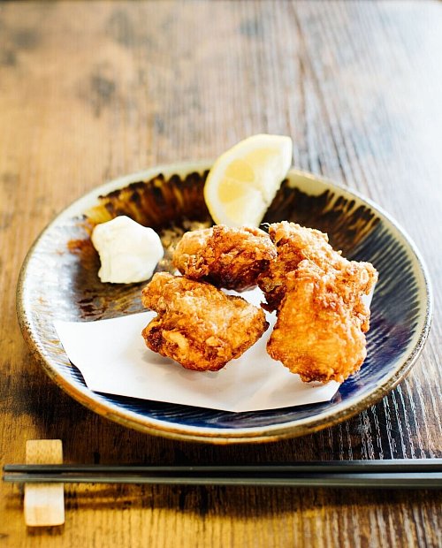 Karaage gehört neben Tempura zu den frittierten Gerichten der japanischen Küche. Dafür wird oft Hähnchen in Sojasoße, Sake und Gewürzen mariniert, in Kartoffelstärke gewendet und dann knusprig frittiert. - © Simi Leistner/Asiastreetfood.com/dpa-tmn