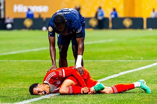 Jamal Musiala liegt nach dem Zusammenprall mit PSG-Torwart Gianluigi Donnarumma verletzt am Boden. - © Malachi Gabriel/ZUMA Press Wire/dpa