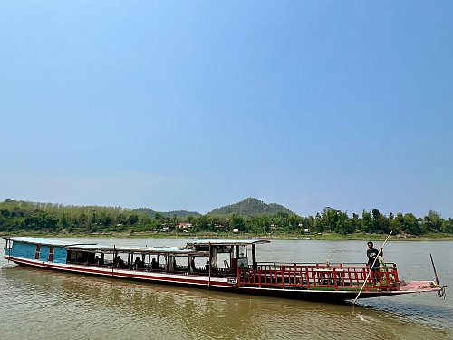 Ein «Slow boat» mit Touristen fährt über den Mekong. Die rechteckigen, bunten Holzboote tuckern gemächlich über den großen Fluss und sind sinnbildlich für die Entspanntheit in Laos. - © Carola Frentzen/dpa-tmn