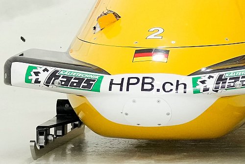 Johannes Lochner beim Start, links im Bob ist das Loch zu sehen. - © Seth Wenig/AP/dpa