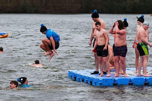 Besonders Mutige schwimmen im Halterner Stausee bis zu Badeplattformen und stehen dann im eisigen Wind, bevor sie erneut ins Wasser springen - © Christoph Reichwein/dpa