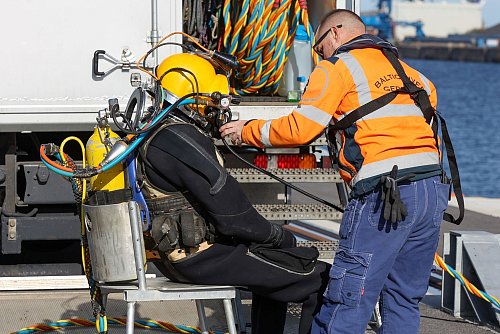 Ein Taucher macht sich im Rostocker Hafen startklar, um den Rumpf des nach einem Brand havarierten Öltankschiffes «Annika» zu kontrollieren. - © Bodo Marks/dpa