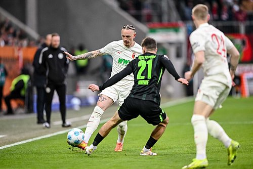 Augsburgs Marius Wolf spielt den Ball an Joakim Maehle von Wolfsburg vorbei. - © Harry Langer/dpa