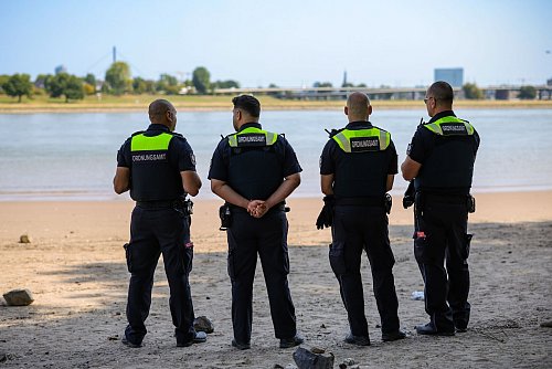 Mitarbeiter des Düsseldorfer Ordnungsamtes kontrollieren das Badeverbot im Rhein. (Archivbild) - © Christoph Reichwein/dpa