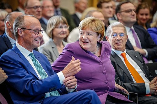 Die Jubilarin flankiert von Friedrich Merz und Ehemann Joachim Sauer. - © Kay Nietfeld/dpa