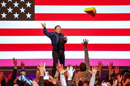 Musk wirft seinen Käsehut während einer Veranstaltung vor der Richterwahl im US-Bundesstaat Wisconsin in die Menschenmenge. - © Jeffrey Phelps/AP/dpa