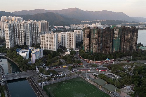 Nach dem Brand in einer Wohnanlage in Hongkong gelten weiterhin rund 200 Personen als vermisst. - © Ng Han Guan/AP/dpa
