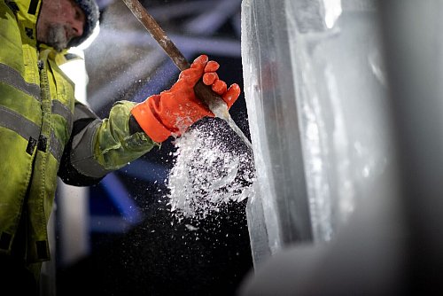 Mit Hammer und Meißel bearbeitet Künstler Martin de Zoete eine Eisskulptur. - © Fabian Strauch/dpa