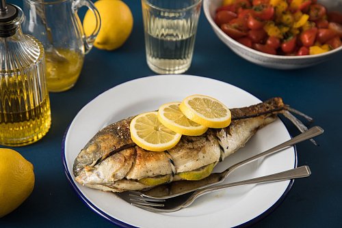 Ein leichtes Abendessen, das nach Urlaub schmeckt: Fisch mit Zitrone und Tomatensalat. - © Christin Klose/dpa-tmn