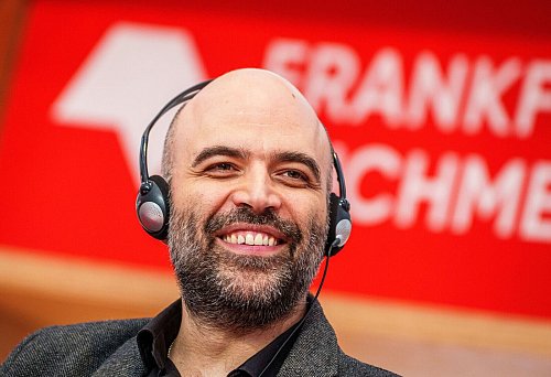 Roberto Saviano, italienischer Autor, lächelt bei einer Diskussionsrunde unter der Überschrift «Schreiben in illiberalen Zeiten». - © Andreas Arnold/dpa