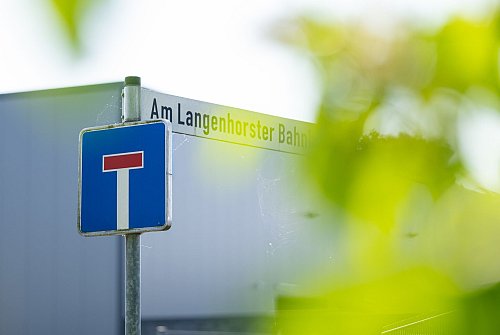 Auf einem Straßenschild steht der Name des Gewerbegebietes: «Am Langenhorster Bahnhof» in dem der Bau des Krematoriums geplant ist. - © Guido Kirchner/dpa