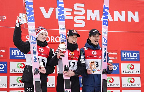 Bei den Siegerehrungen können die deutschen Skispringer derzeit nur zuschauen. - © Uncredited/Kyodo News/AP/dpa