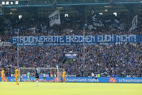 Fans von Arminia Bielefeld zeigen Solidarität mit von Stadionverboten Betroffenen. - © Friso Gentsch/dpa