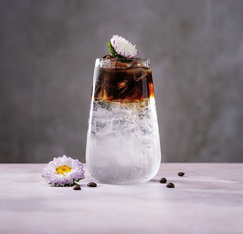 «Flower Power», mal ganz ohne Alkohol: Tonic Water, Holunderblütensirup und Eiswürfel werden mit Kaffee gefloatet. Das heißt, der Kaffee kommt so in den Drink, dass er auf den anderen Zutaten schwimmt. Das gelingt mit vorsichtigem Gießen über einen Barlöffel. - © Daniel Esswein/dpa-tmn