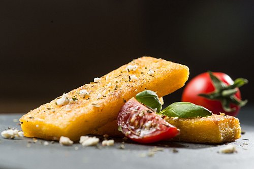 Wer keinen Polenta-Brei mag, kann daraus auch Schnitten machen. Einfach breit streichen, abkühlen lassen und braten. Dazu passen Tomaten, Feta und Basilikum. - © Franziska Gabbert/dpa-tmn