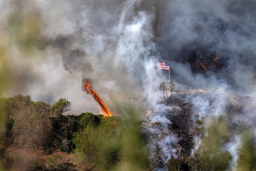 Eine amerikanische Flagge weht über einem Teil des Mandeville Canyon - © Mark Edward Harris/ZUMA Press Wire/dpa
