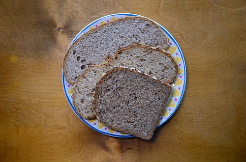 Scheiben von Mischbrot, Vollkornbrot und Kürbiskernbrot liegen auf einem Teller. (Symbolbild) - © Robert Michael/dpa