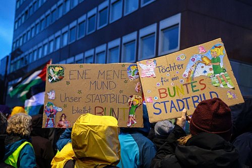 Eine Teilnehmerin hält ein Schild mit der Aufschrift «Töchter für ein buntes Stadtbild» bei der Protest-Aktion nach den Aussagen von Bundeskanzler Merz zu Stadtbild und Migration. - © Alex Talash/dpa