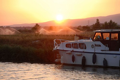 Weinberge in der Region Minervois: Wenn die Sonne versinkt, ruht der Schiffsverkehr auf dem Canal du Midi in Südfrankreich. - © Christian Röwekamp/dpa-tmn
