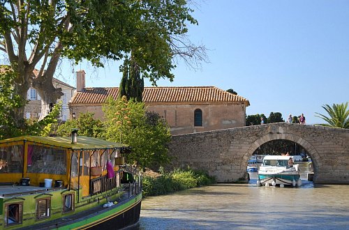 Millimeterarbeit auf dem Canal du Midi: Immer wieder müssen Hausbootkapitäne - wie hier in Le Somail - durch enge Brücken navigieren. - © Christian Röwekamp/dpa-tmn
