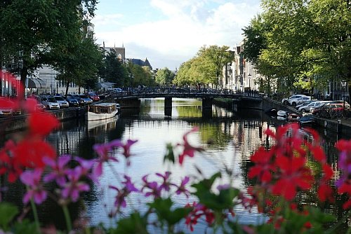 Gracht in Amsterdam: Die niederländische Stadt kann man auch mit dem Hausboot erkunden. - © Andrea Warnecke/dpa-tmn